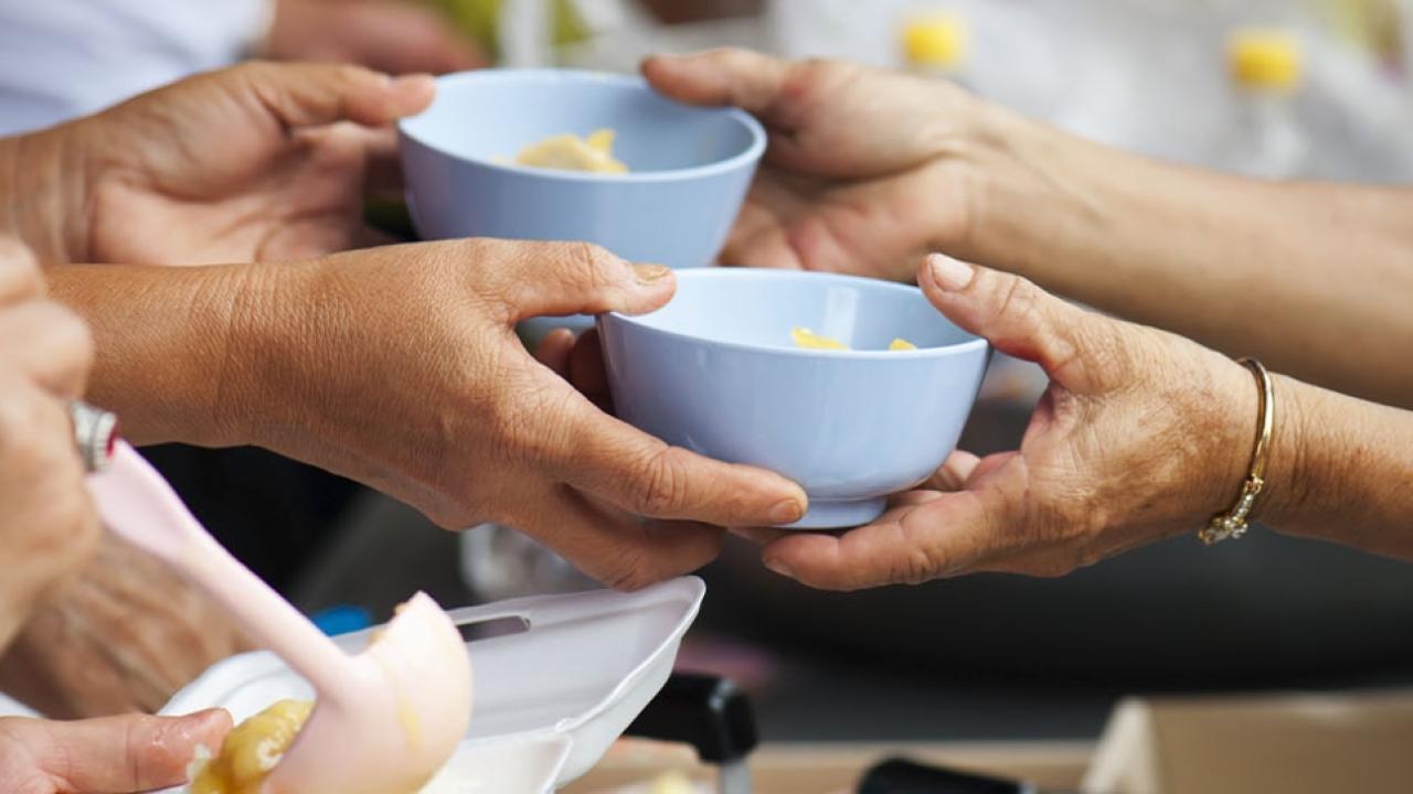 Hands sharing bowls of food