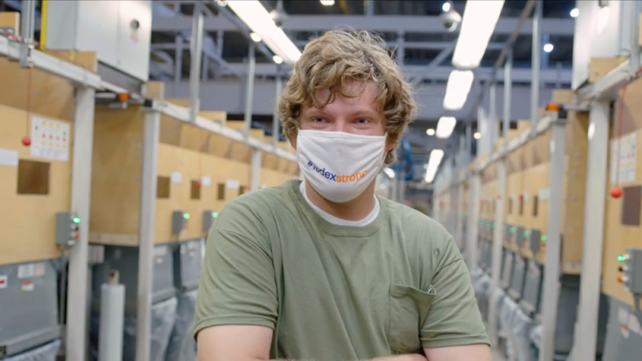 Photo of man in green t-shirt with a mask covering his nose and mouth