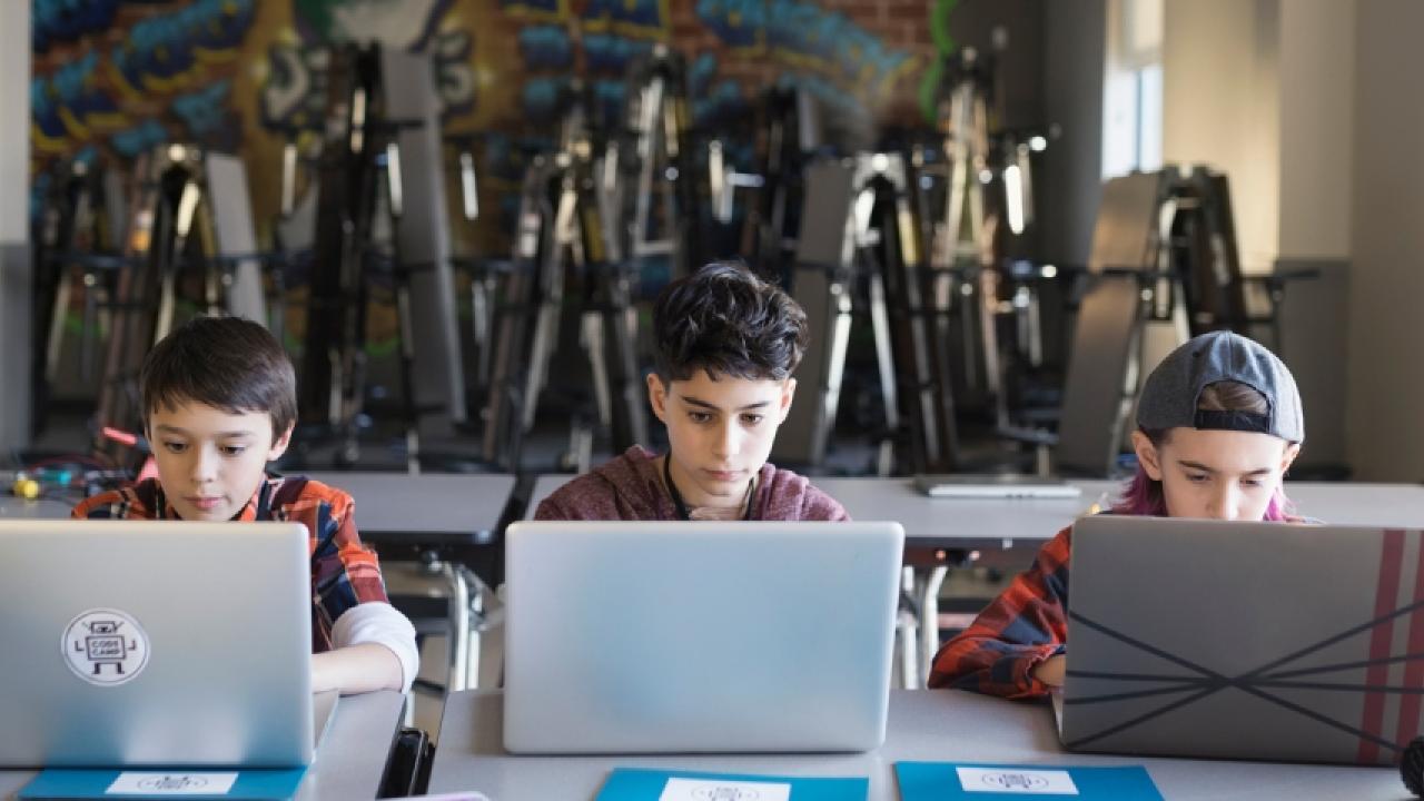 3 kids using laptops