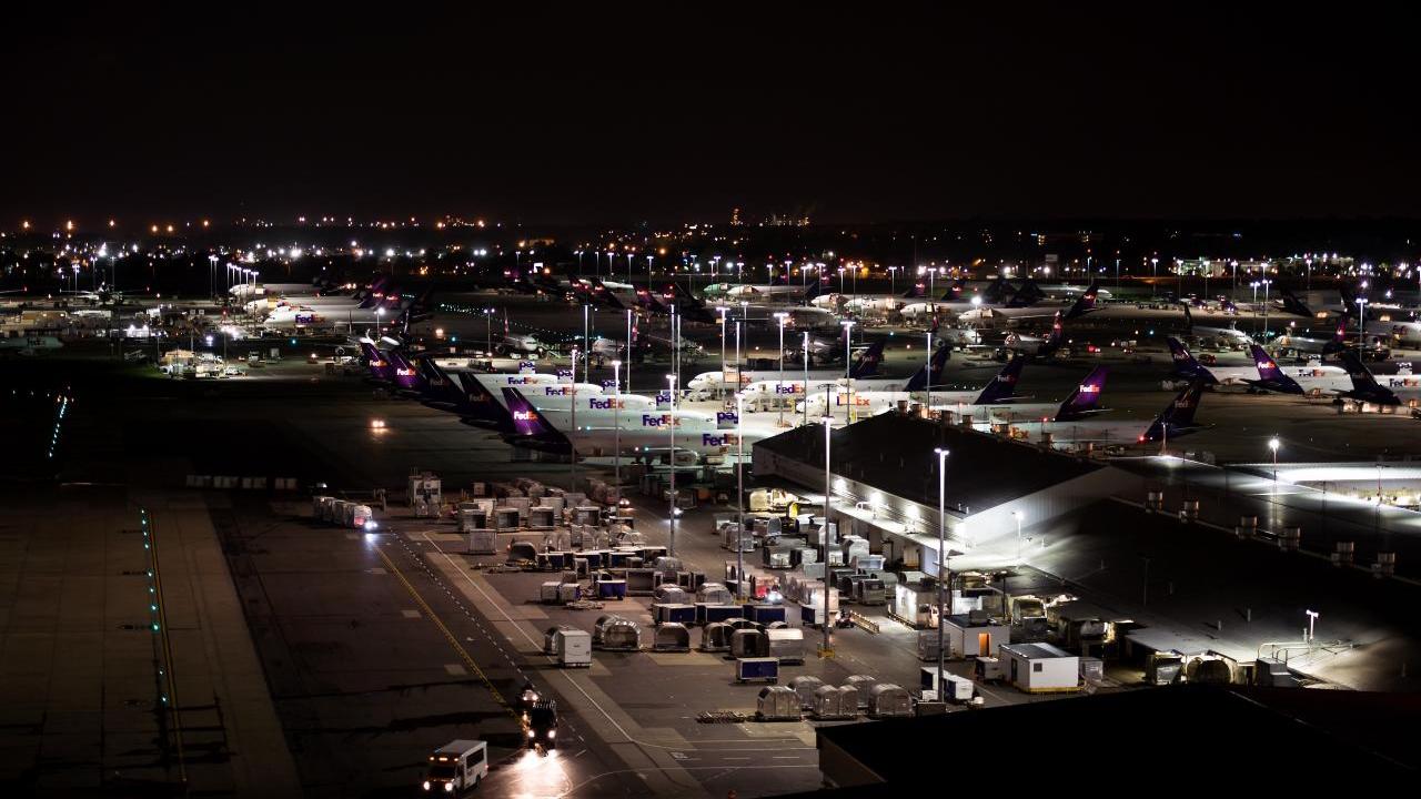 Aerial view of FedEx planes and cargo at an airport at night