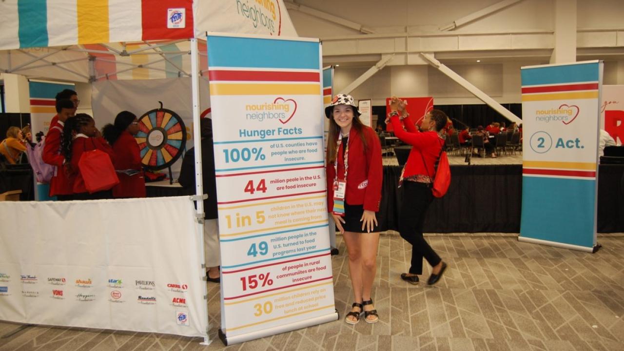 Person posing by sign with hunger facts