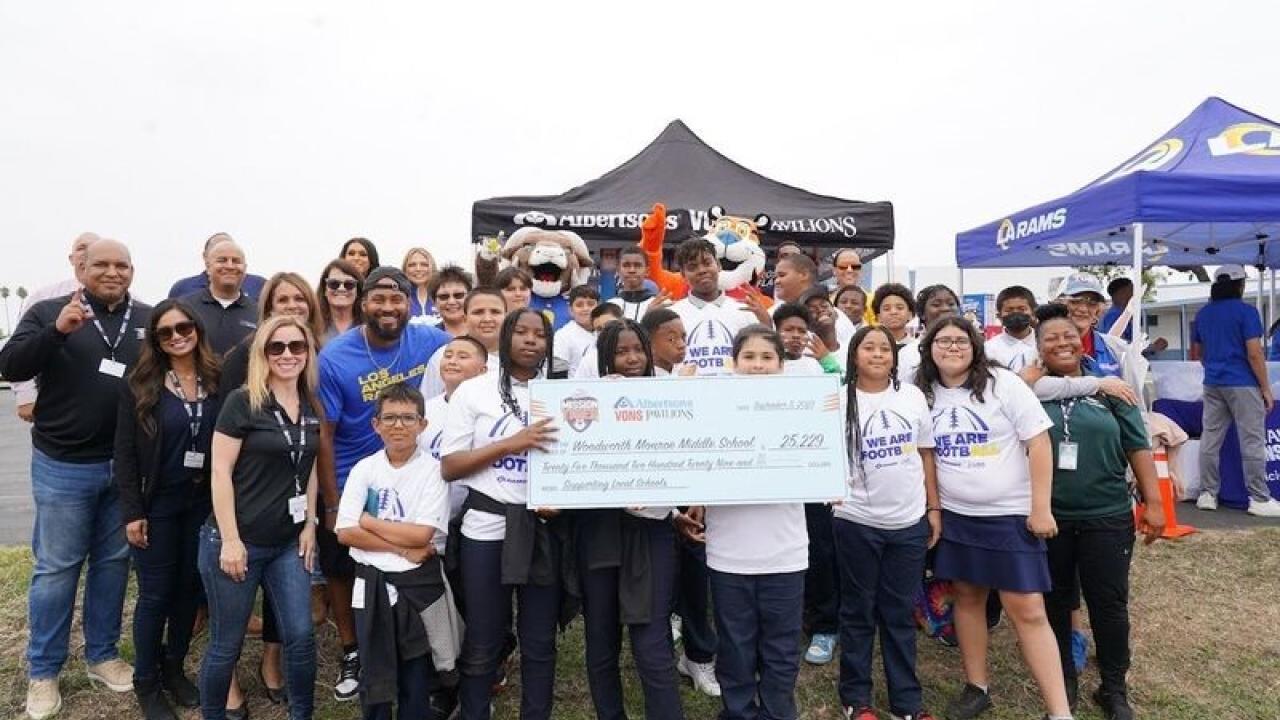 Group of people holding a check in front of Albertsons' tent