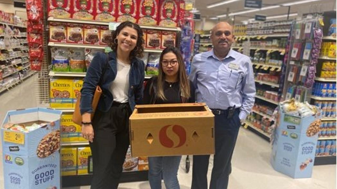 Group of people in store holding Safeway donation box
