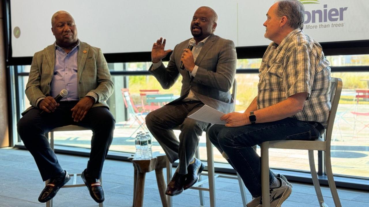 Three people sat on chairs having a discussion 
