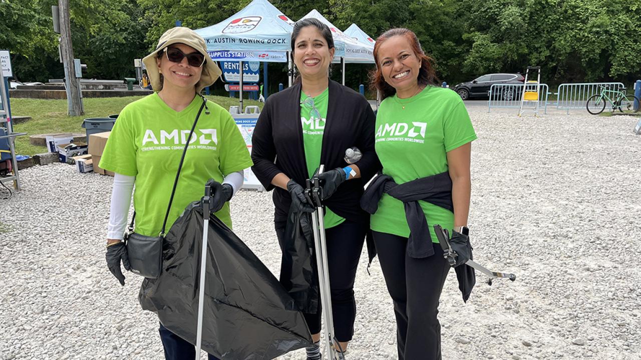 Three people standing together in green AMD t-shirts