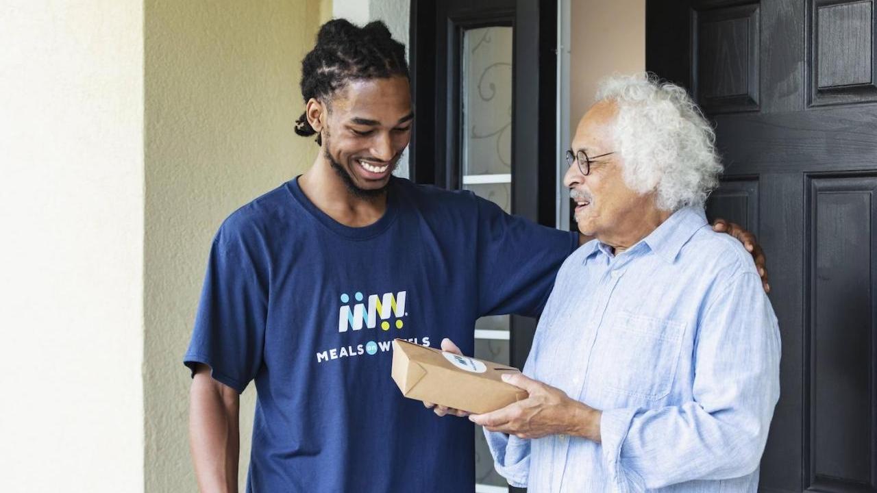 A meal is delivered to a Meals on Wheels recipient
