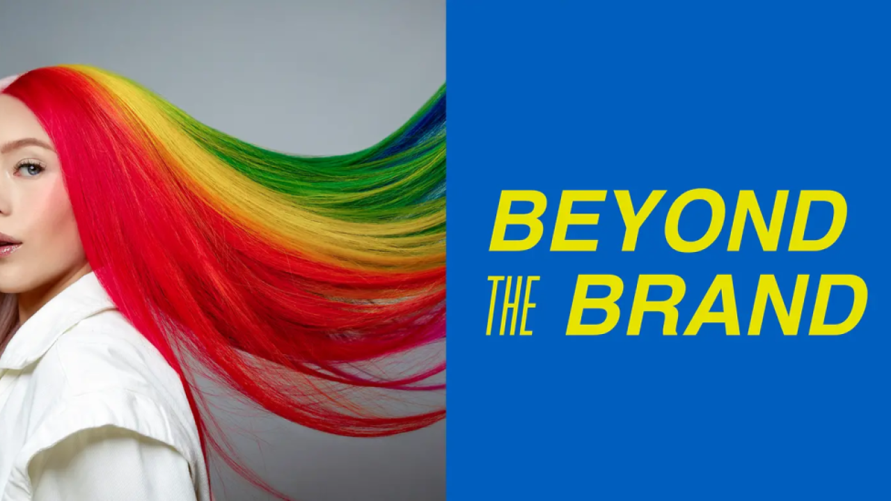 A person with long rainbow hair and the phrase: Beyond the Brand
