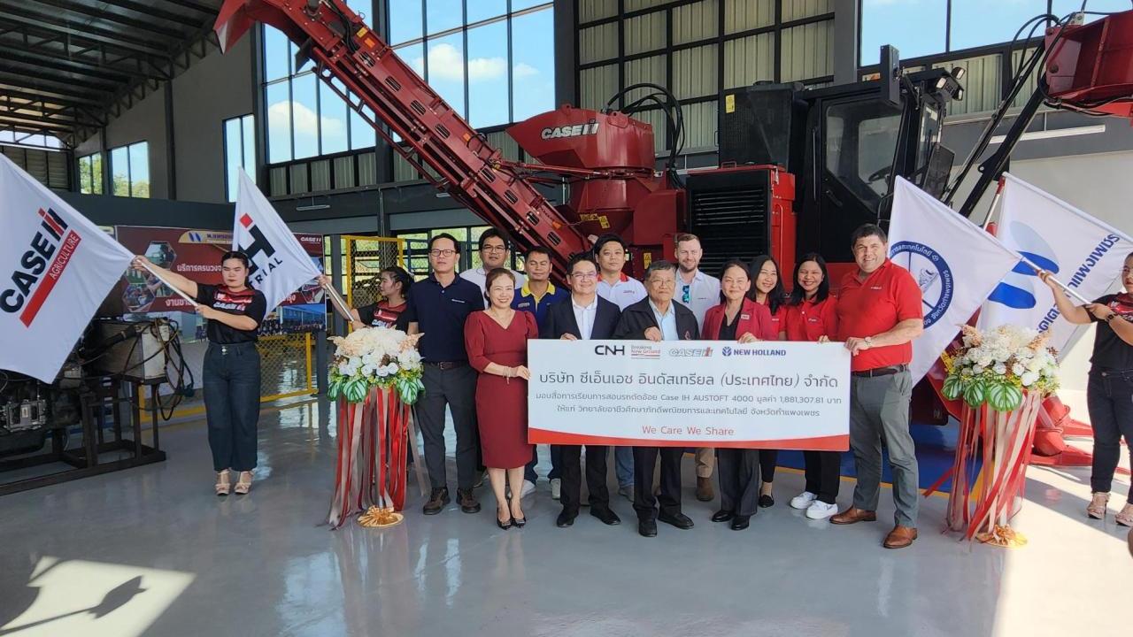 A group of people stood in front of agricultural machinery 