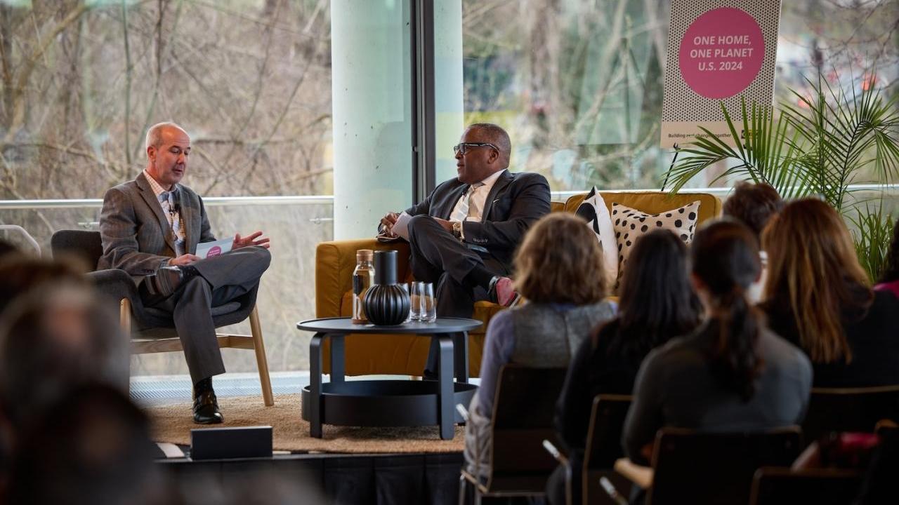 People talking on a stage with an audience listening