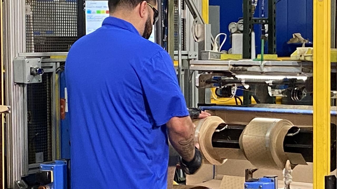A person standing at a machine