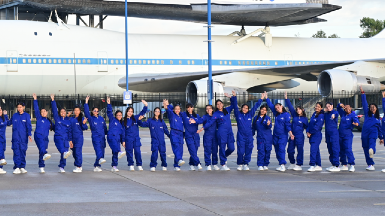 She Is an Astronaut participants in a line in front of a Nasa airplane