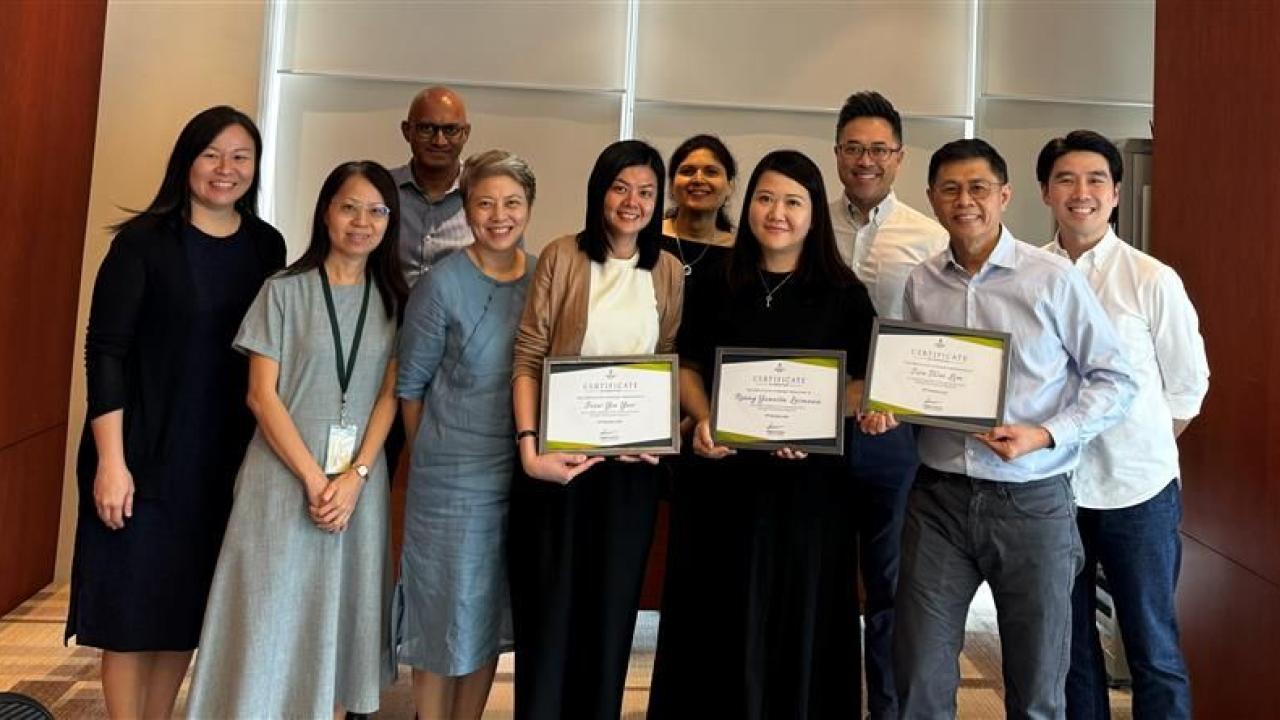 A group of people standing together, holding diplomas