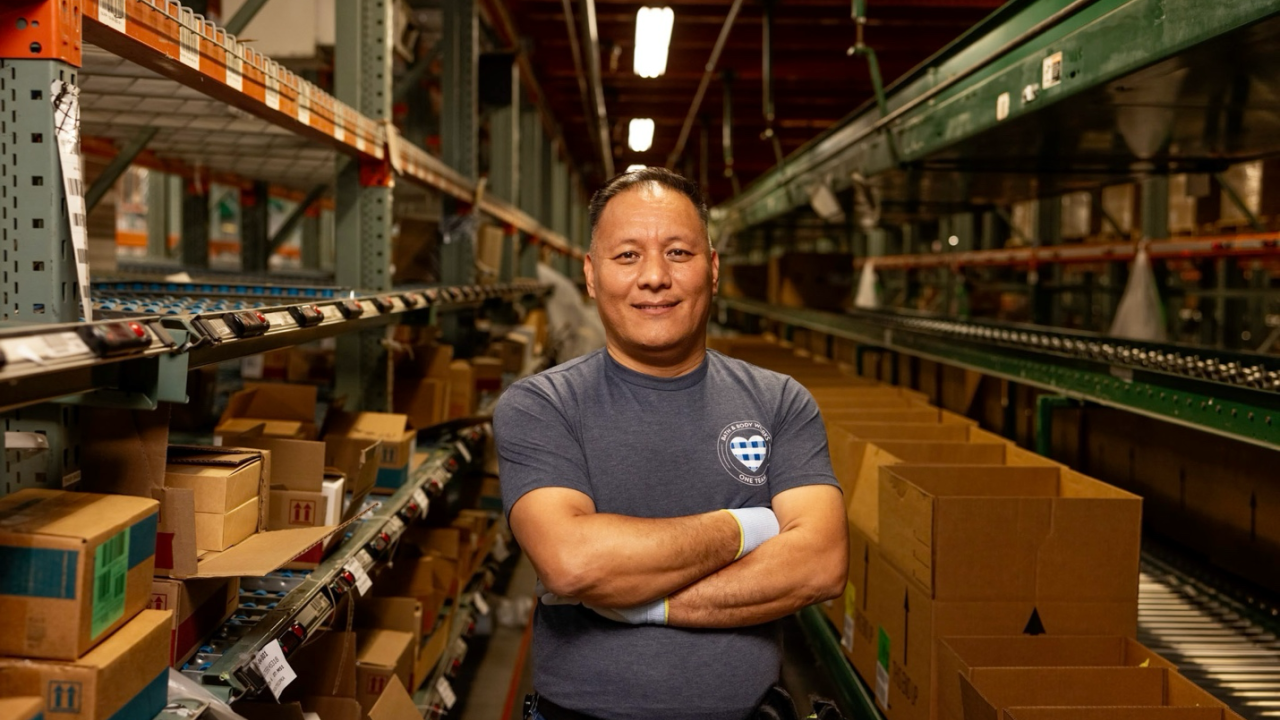 A person standing in a warehouse surrounded by shelves and boxes