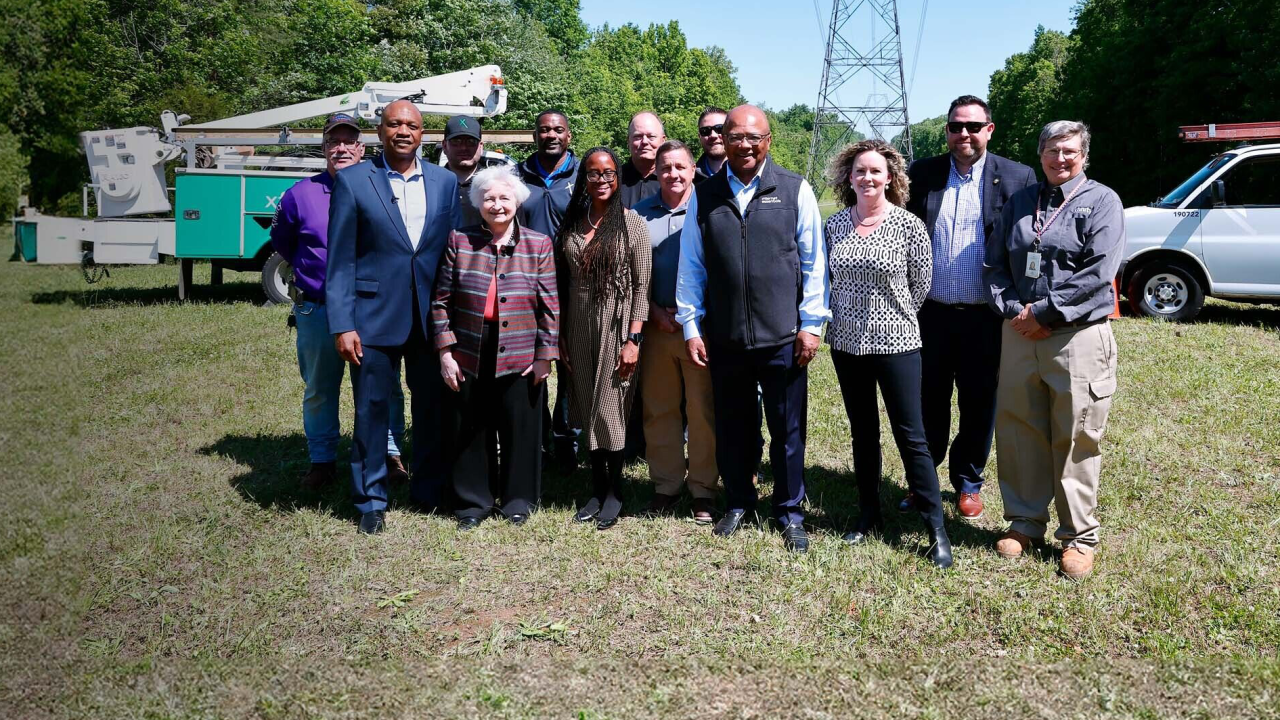People standing together in a field in front of communication equipment