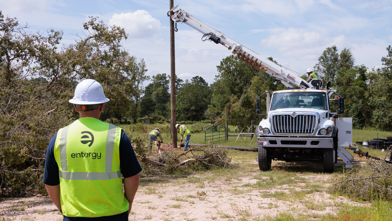 Worker in high-vis vest watching electrical work being done