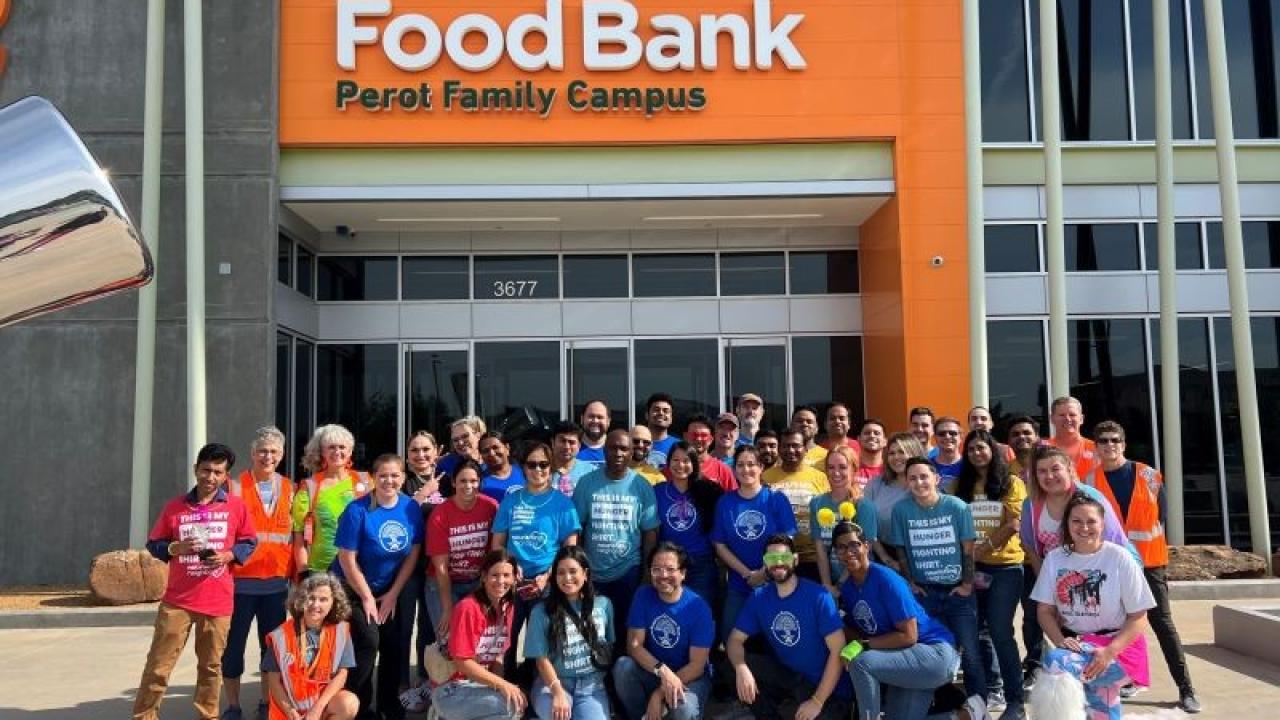 Albertsons associates pose for group picture in front of North Texas Food Bank.