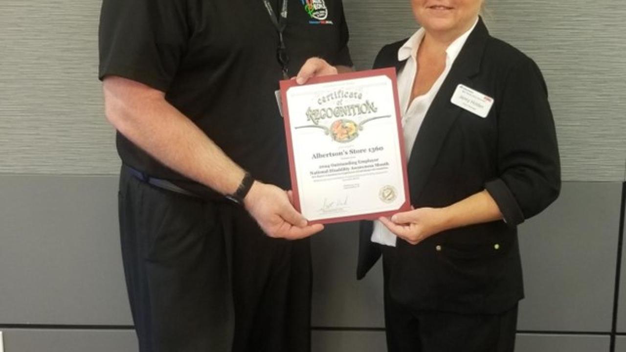 Two people holding a plaque