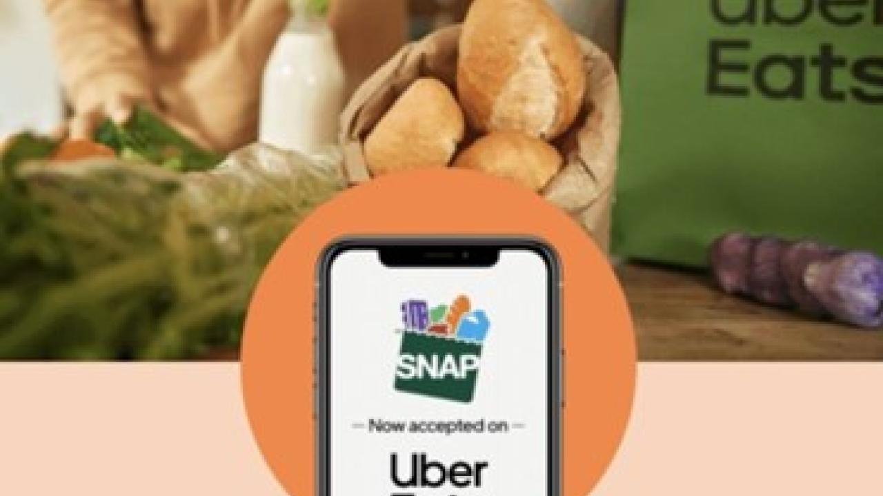Image of groceries with phone screen that says "SNAP Now accepted on Uber Eats"