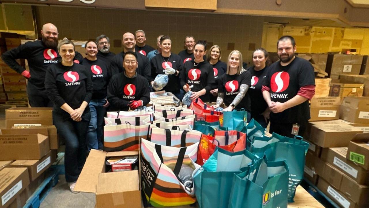 Group of people with Safeway shirts posing for picture