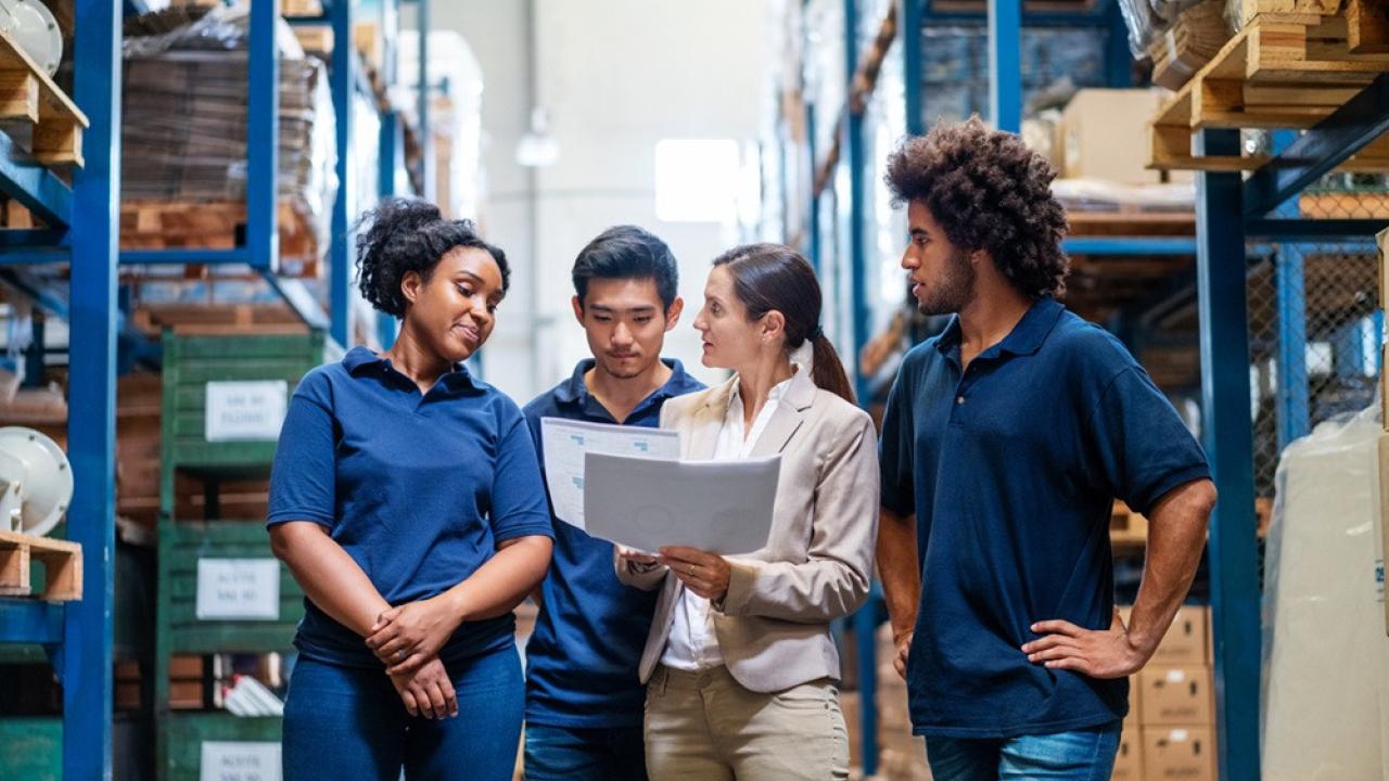 Four person team meeting in a warehouse