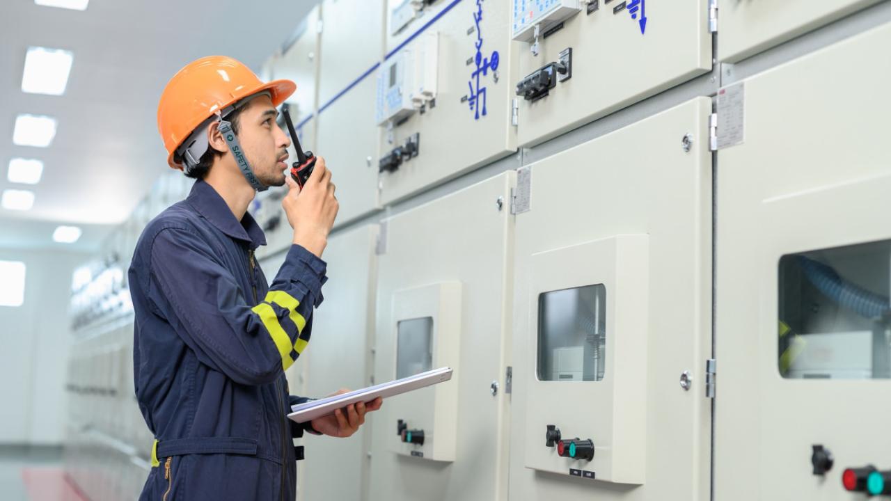 Facility worker in PPE speaking into a radio
