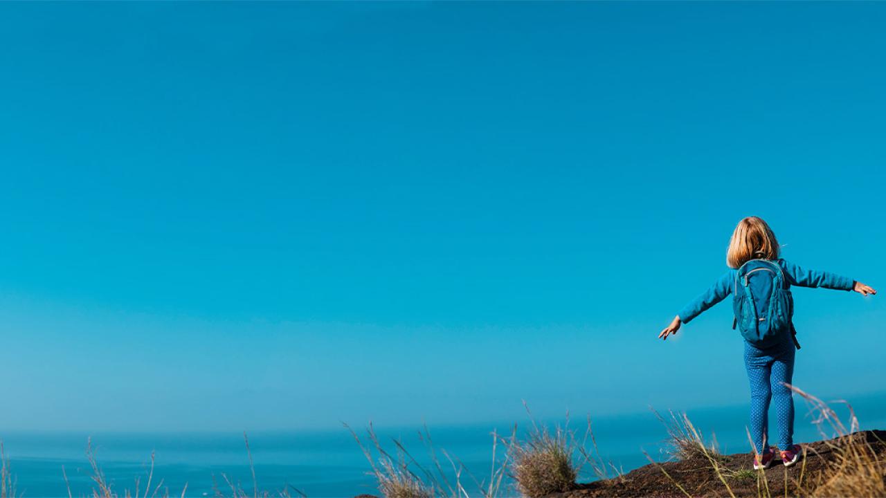 Person with arms out at the edge of a cliff