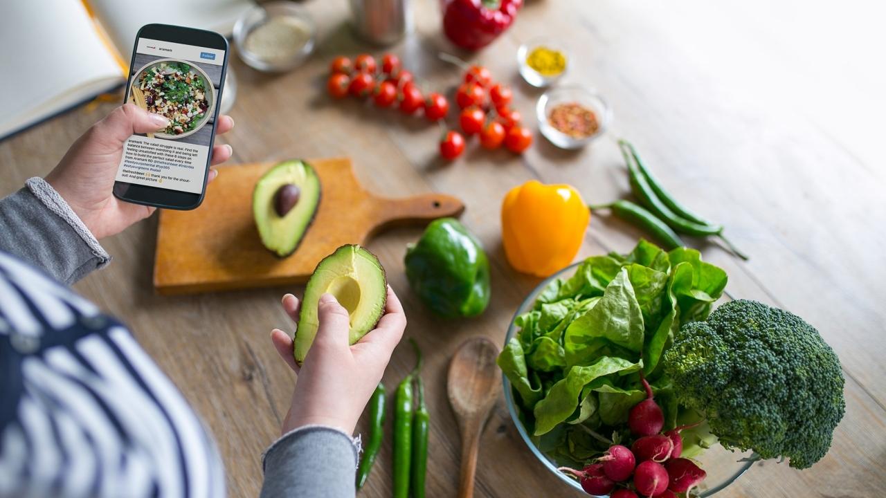 Preparing a meal while looking on a smartphone