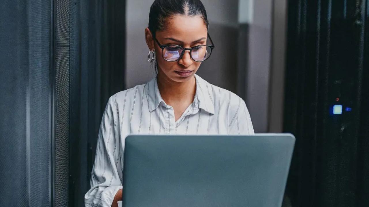 Person standing with open laptop