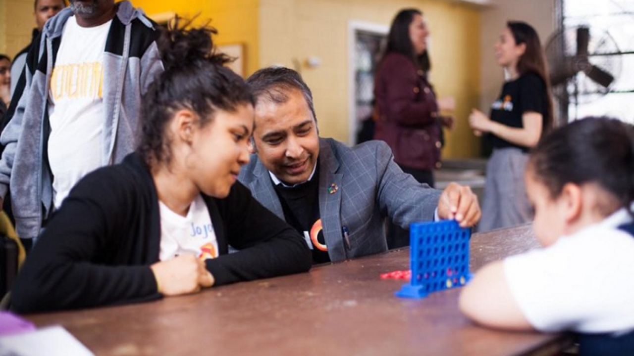 Balaji Ganapathy plays connect four with two students 