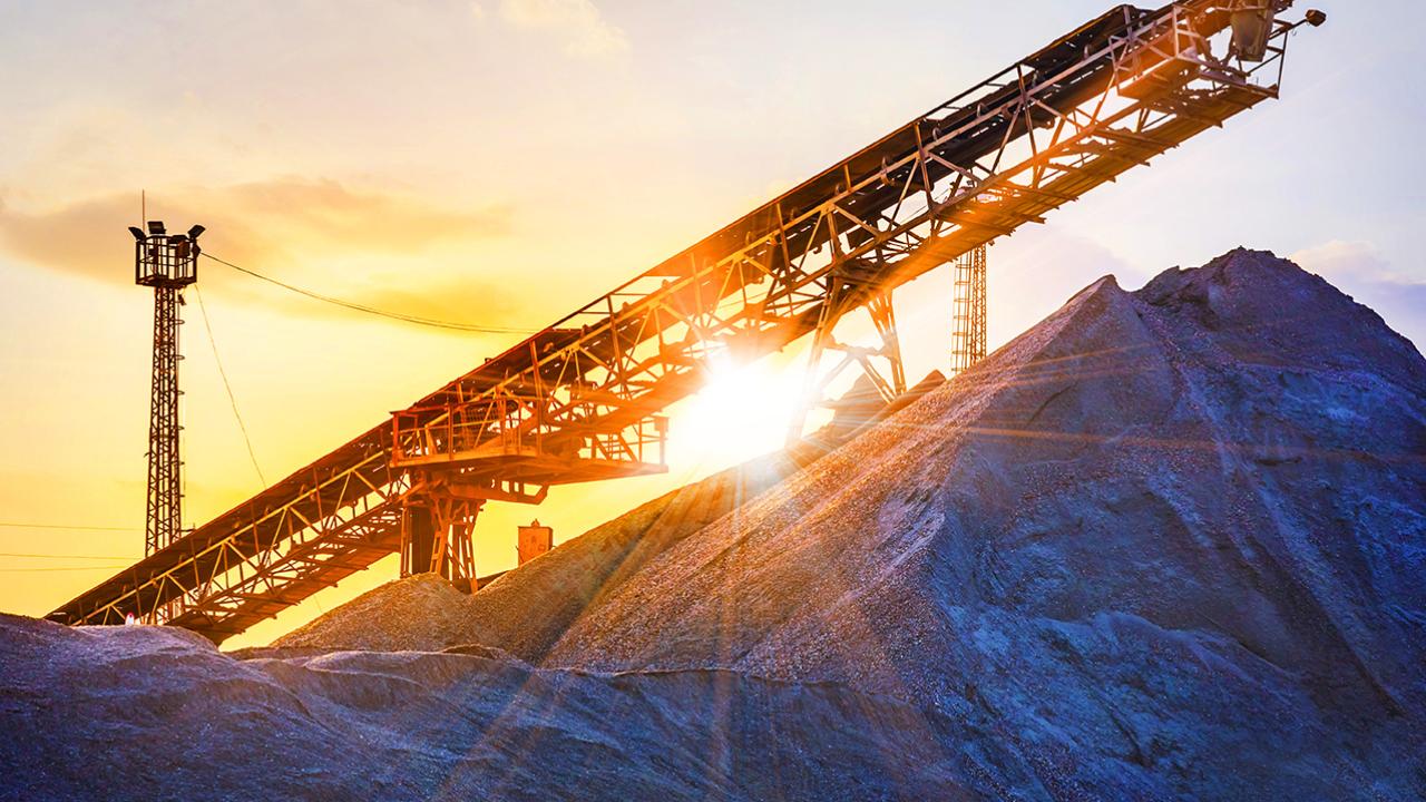 Mining equipment with a sunrise behind it