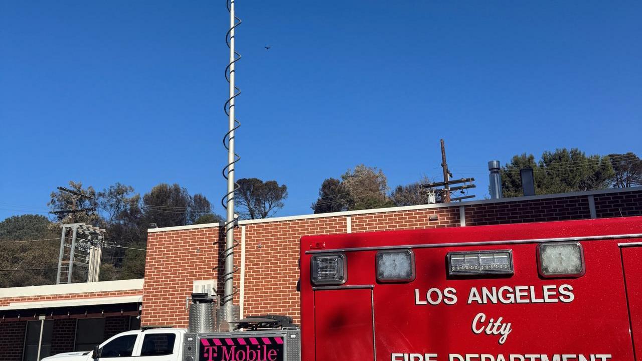 Emergency and T-Mobile vehicles in front of a building