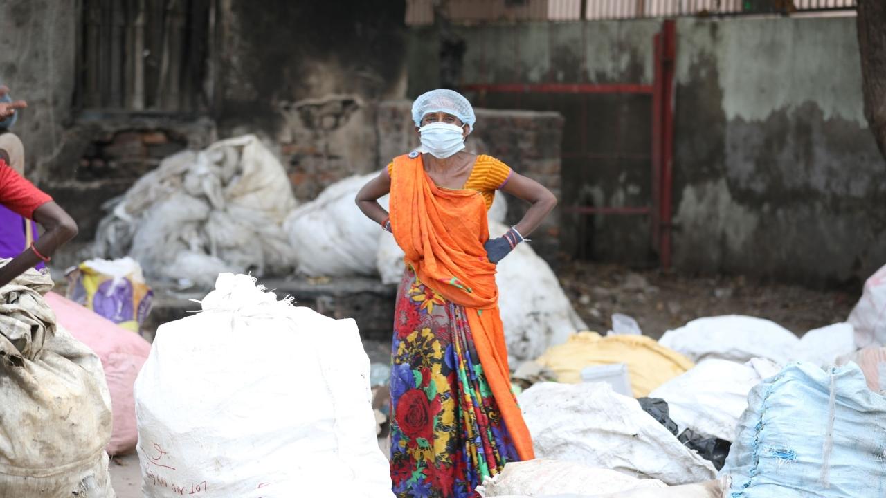 person standing next to recycling bags
