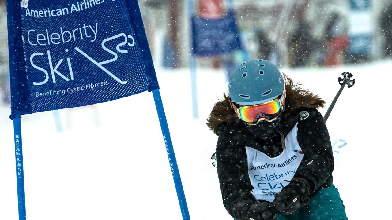 Person skiing next to a "celebrity ski" banner