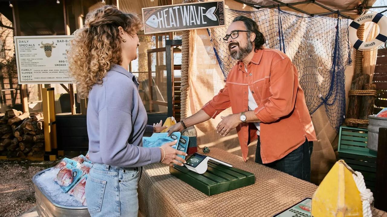 Client speaking with a business owner at a booth.