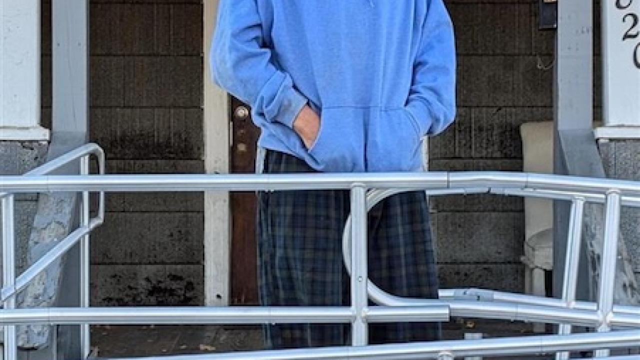 Roy shown in front of his house on the wheelchair ramp.