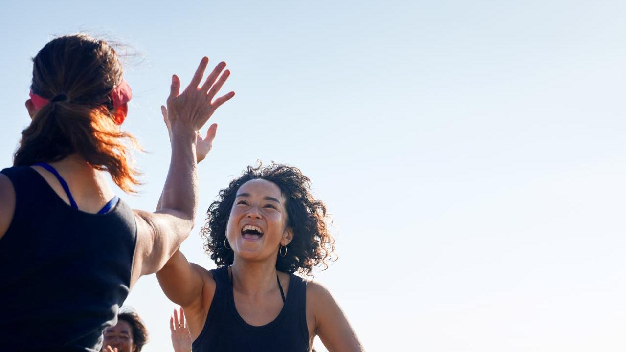 Two people high-fiving outside