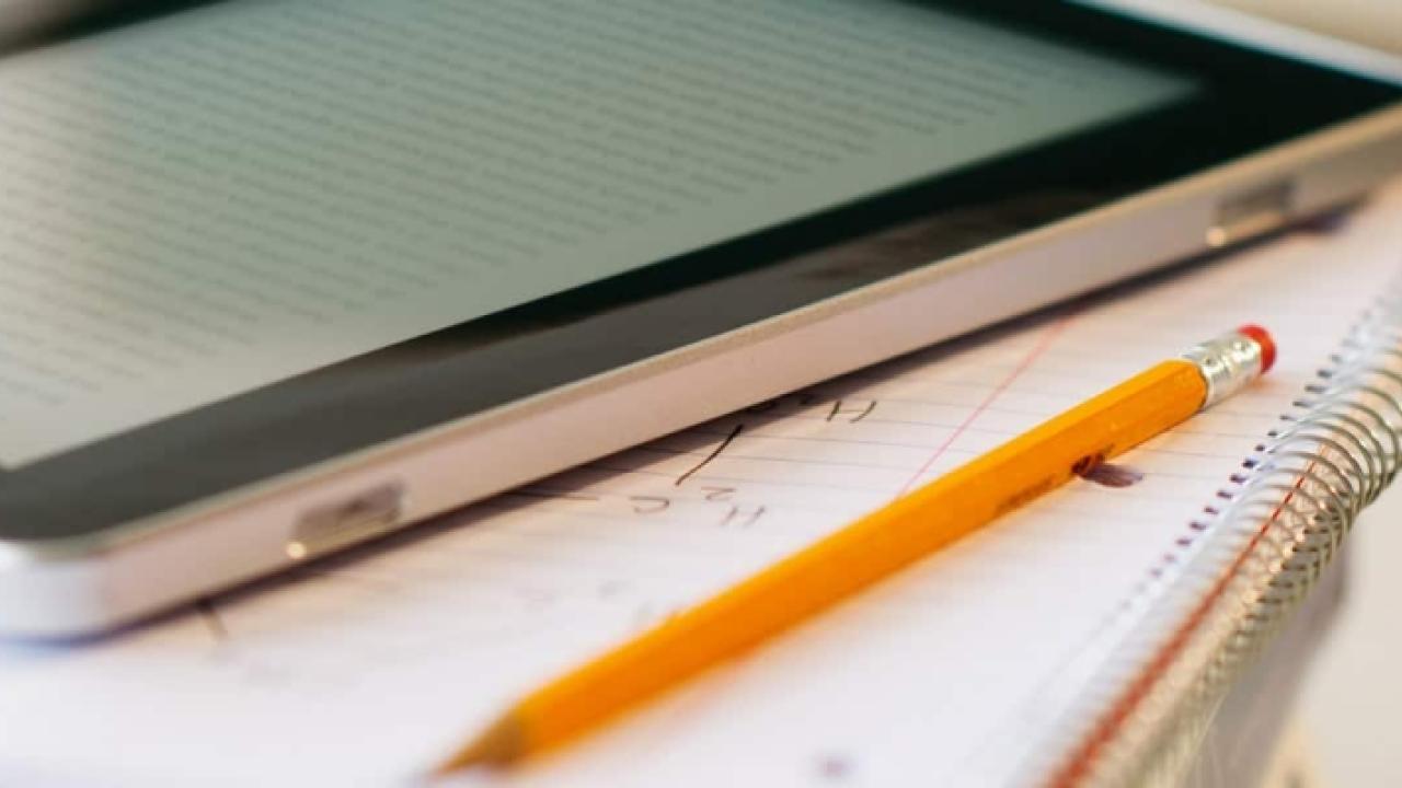 a tablet and a pencil and notebook