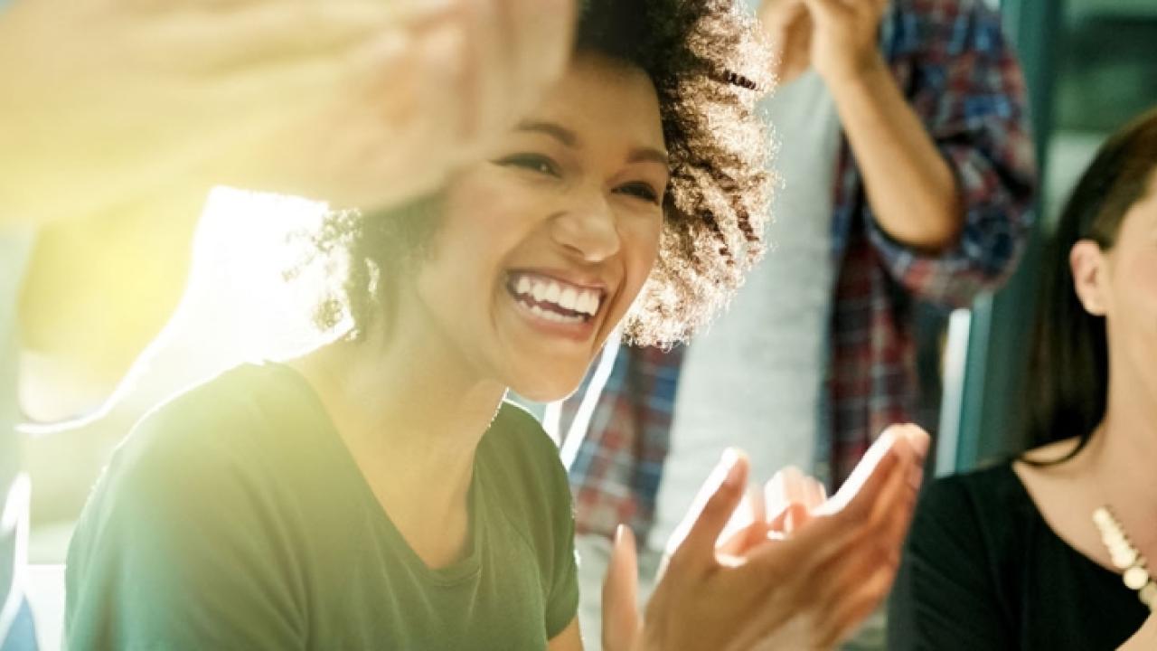 photo of two women in a crowd clapping 