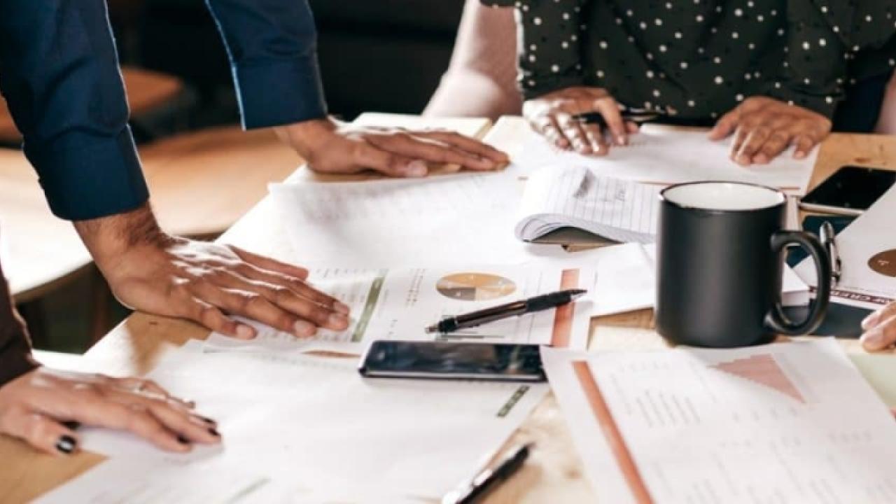 photo of hands on a work area covered with paperwork