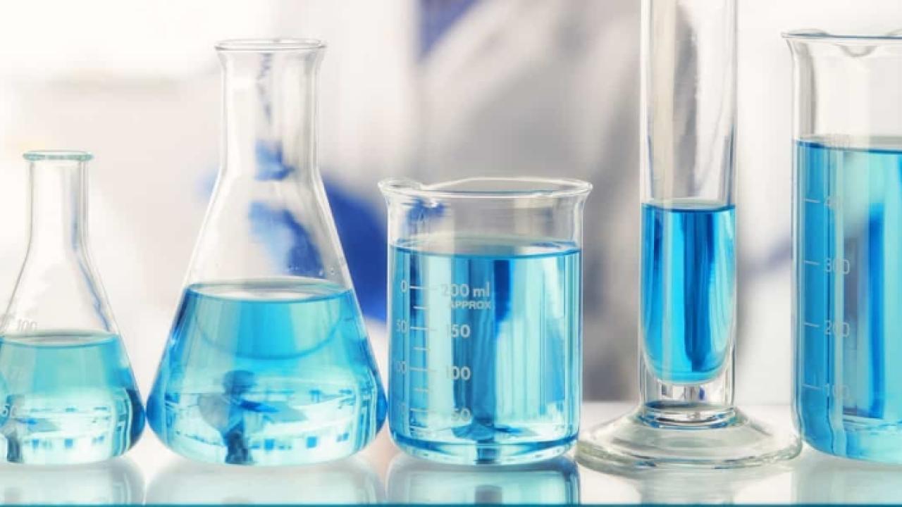 series of measuring glasses with light blue liquid