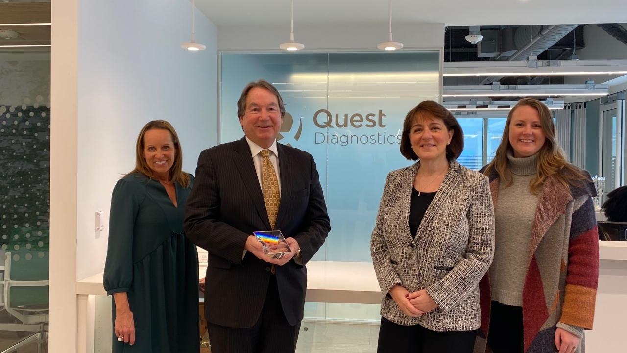 4 people standing in front of Quest Diagnostics logo