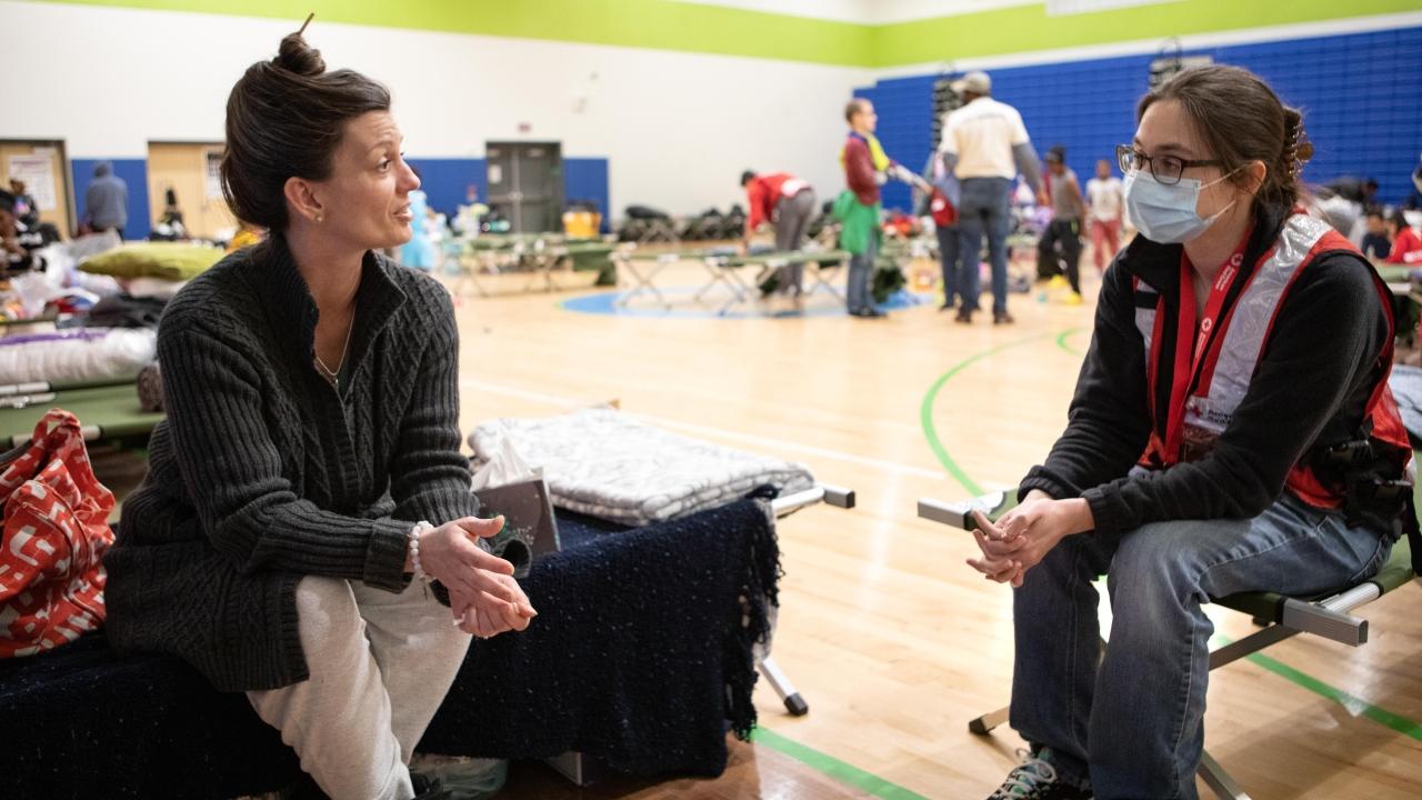 two people talk in a Red Cross shelter