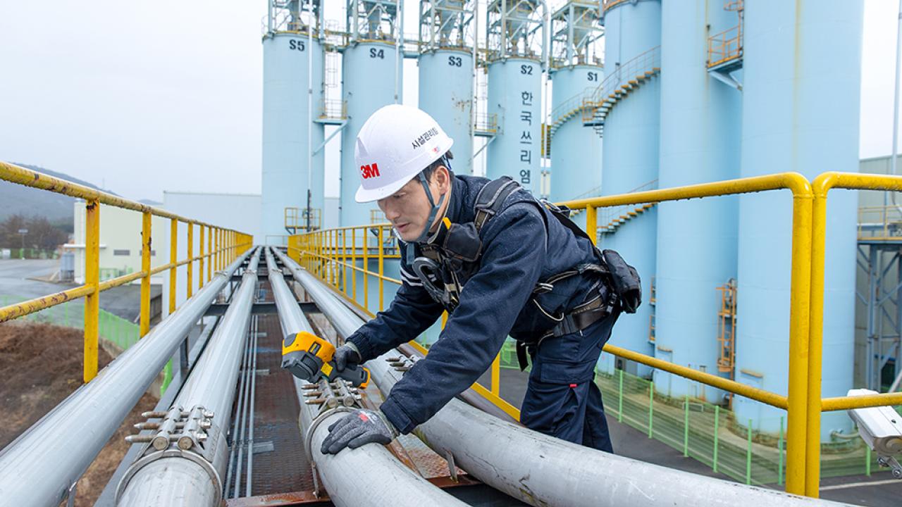 3M technician inspecting pipes at a factory.