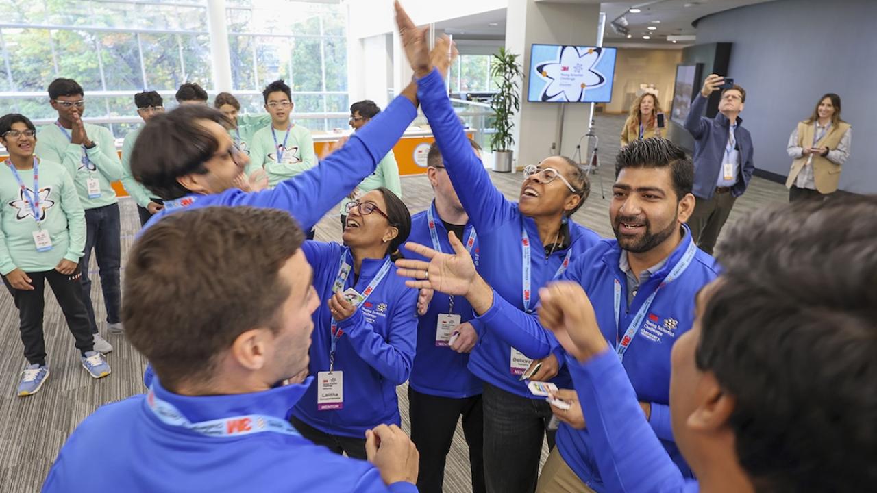 3M Young Scientists giving a high five.