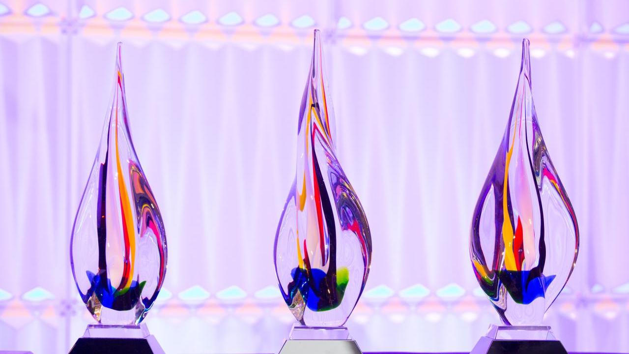 Three large glass awards arranged on a table