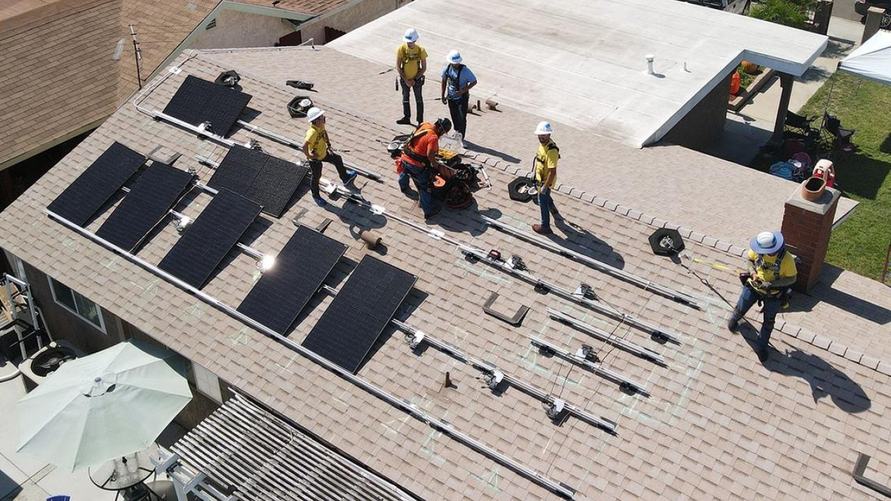 Birdseye view of Edison volunteers installing solar panels on a roof