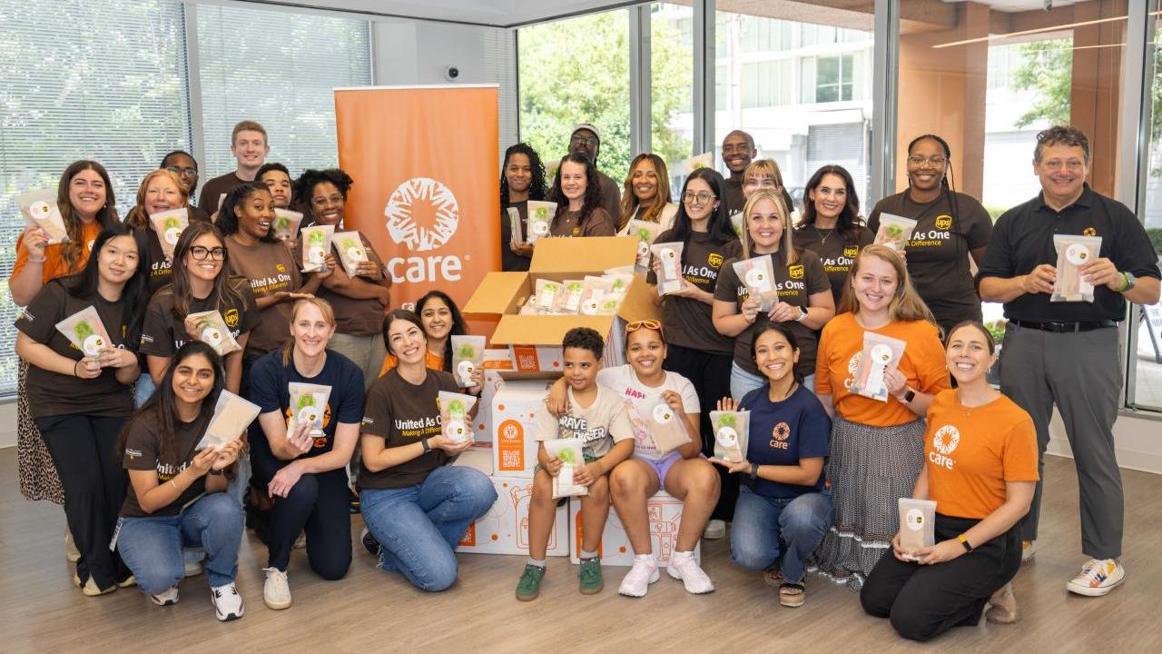 volunteers posing for a group photo with CARE packages
