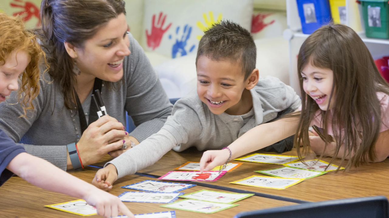 3 children doing a project with a teacher