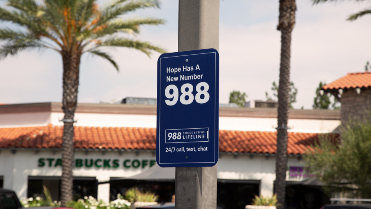 blue 988 sign with palm trees in the background