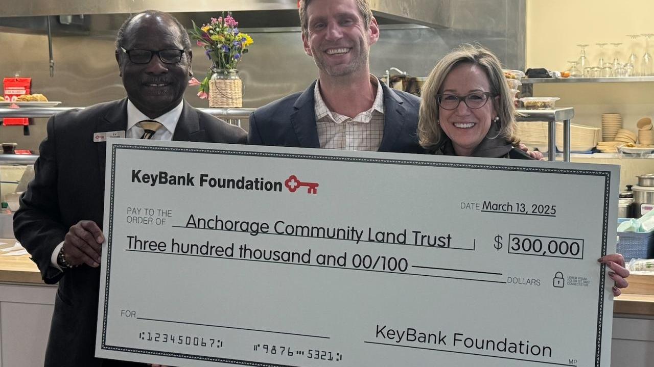 3 people hold a KeyBank Foundation check for $300,000.